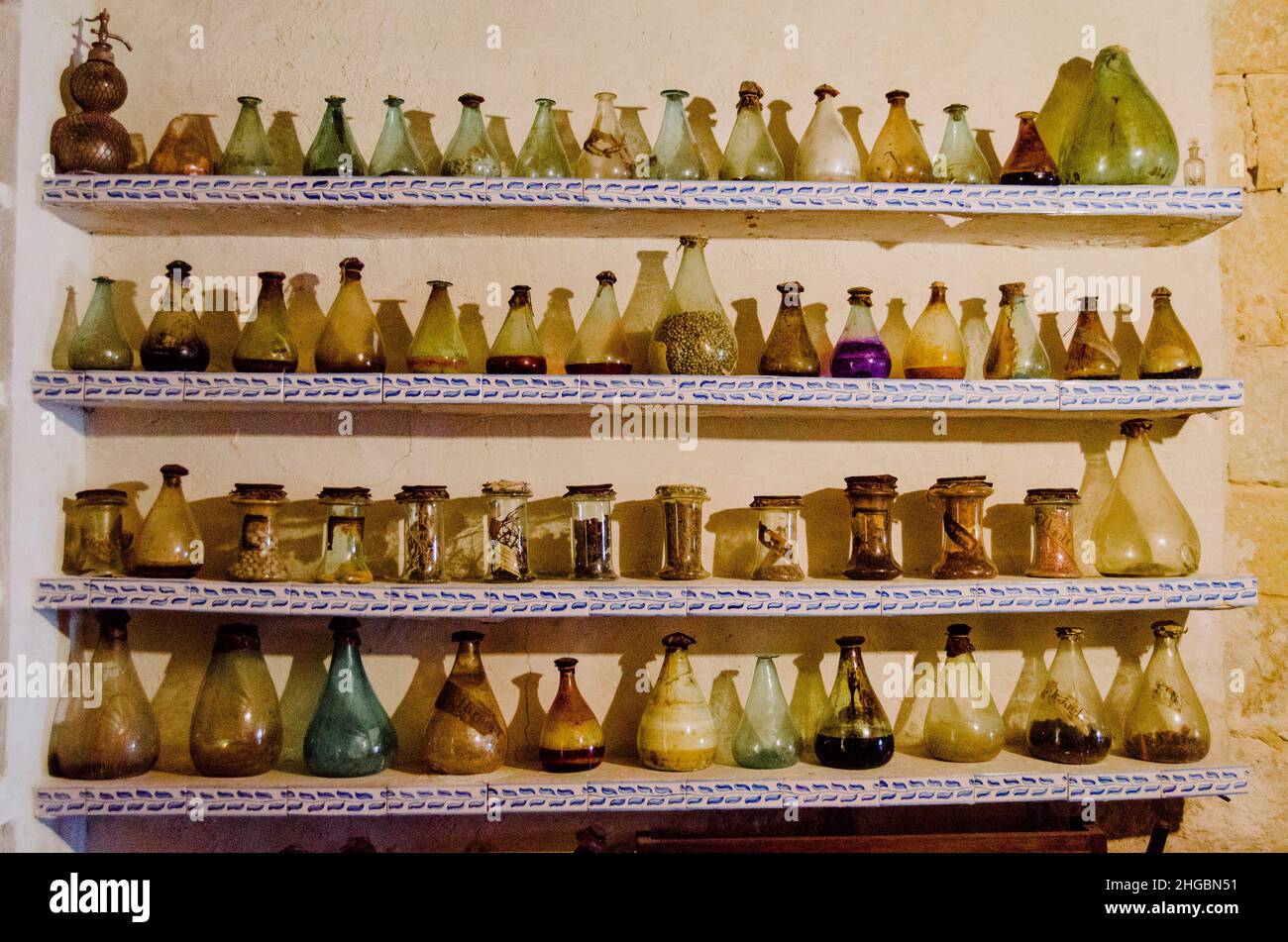 Alte Glasflaschen und Flaschen auf vier Regalen in der Apotheke des Klosters Santo Domingo de Silos, Burgos, Castilla y León, Spanien. Stockfoto