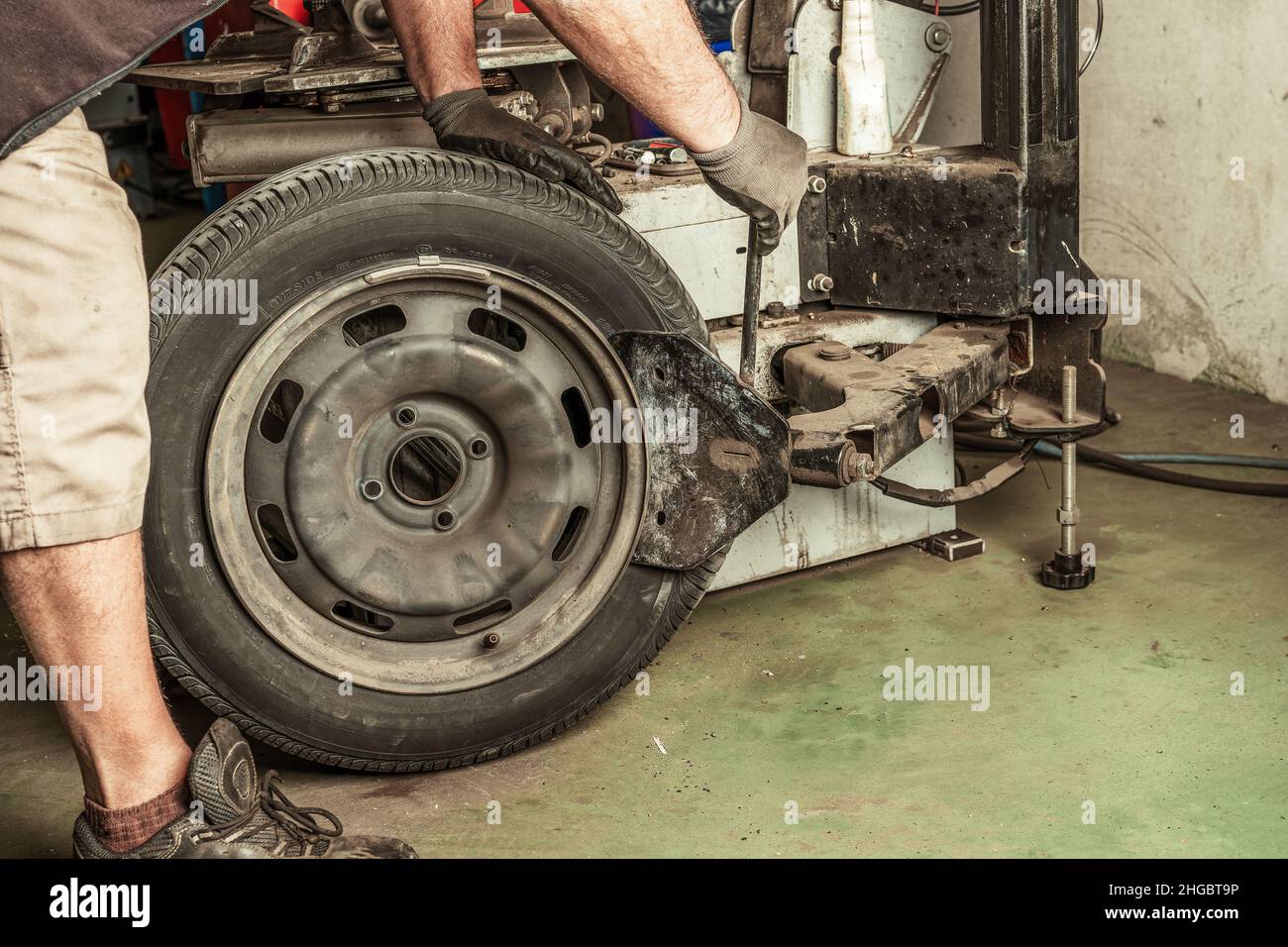 Mechaniker repariert ein Rad mit Werkzeugen in einer Garage Stockfoto