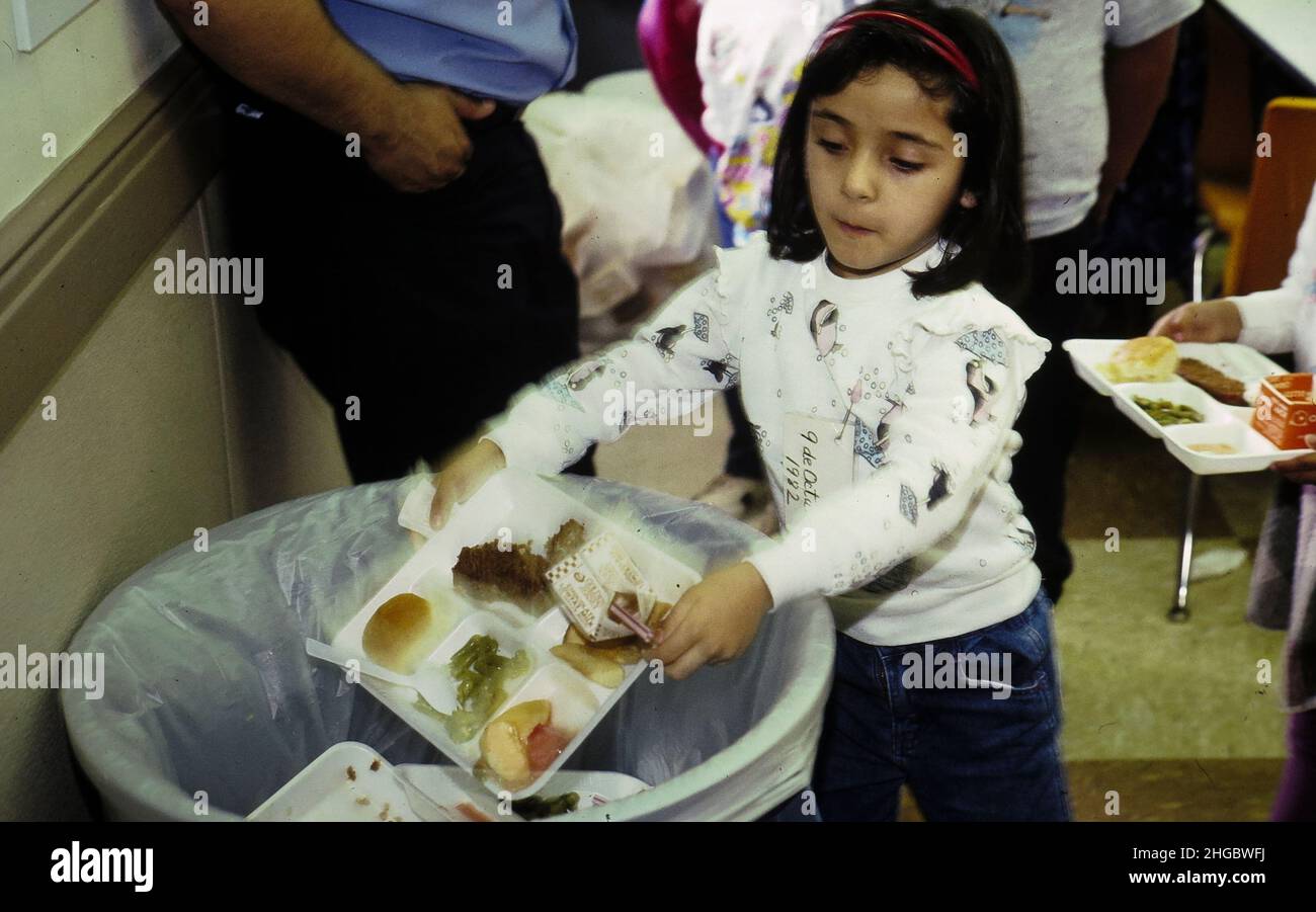 Austin, Texas USA 1990: Hispanische Kindergärtnerin wirft Essen nach dem Mittagessen weg. Keine Freigabe. XX Stockfoto
