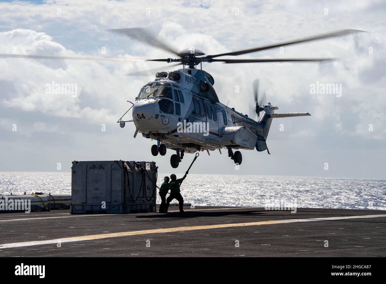 220118-N-MD461-1598 PHILIPPINISCHES MEER (JAN 18, 2022) Matrosen befestigen während einer vertikalen Auffüllung auf See mit Perry am 18. Januar 2022 an einem Super Puma aus dem Jahr EC225, das dem Trockenfracht- und Munitionsschiff der Henry J. Kaiser-Klasse USNS Matthew Perry (T-AKE 9) auf dem Flugdeck des Nimitz-Klasse-Flugzeugträgers USS Carl Vinson (CVN 70) zugewiesen wurde. Die USS Carl Vinson und USNS Matthew Perry, die als Teil der US-Pazifikflotte tätig sind, führen Schulungen durch, um eine freie und offene Region im Indopazifik zu erhalten und zu schützen. (USA Navy Foto von Mass Communication Specialist 3rd Class Jeff D. Kempton) Stockfoto