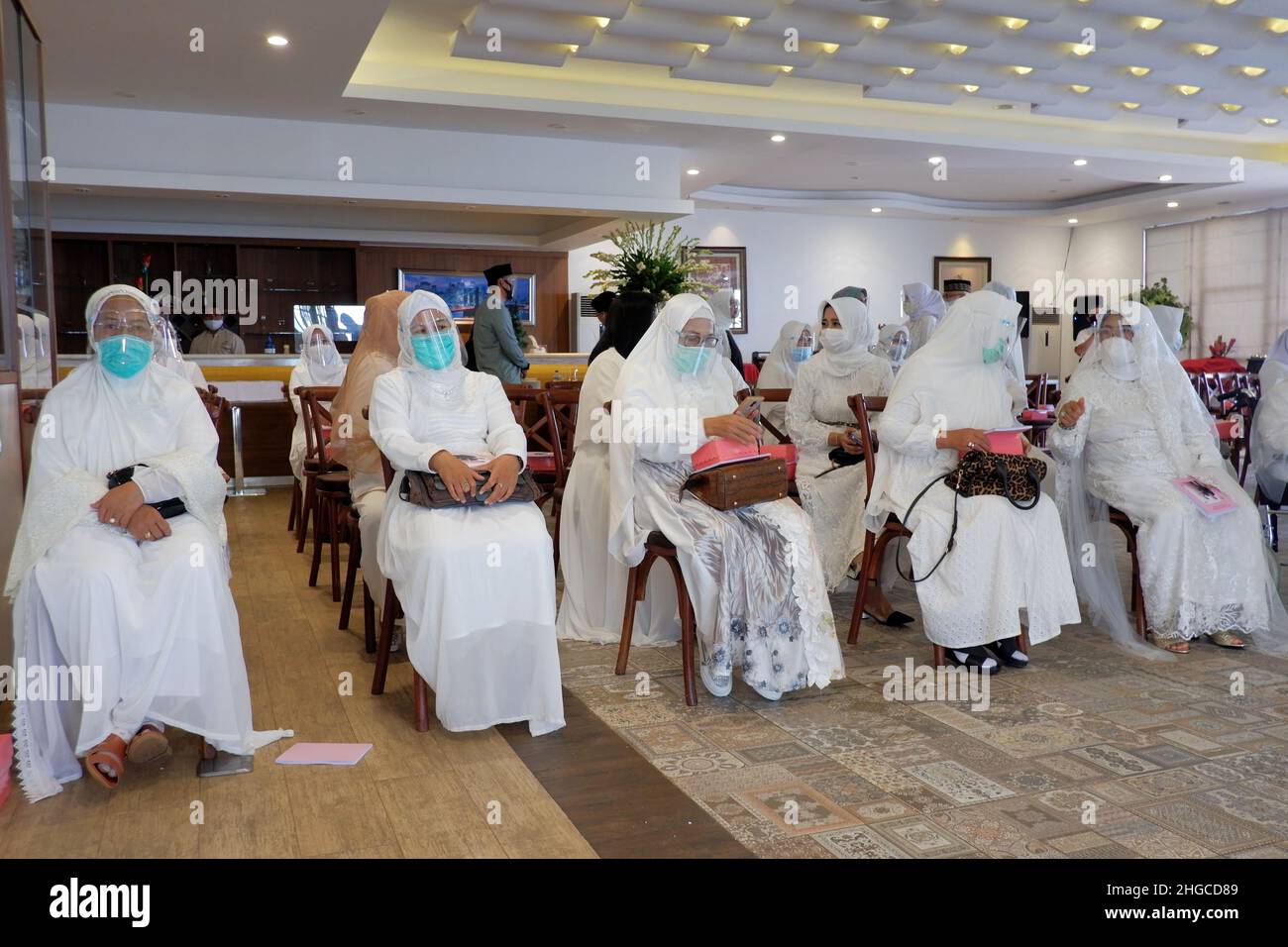 Jakarta, Indonesien - Dezember 2020 : Eine Gruppe muslimischer Frauen trägt Gesichtsmaske und Gesichtsschutz in einem Raum. Stockfoto