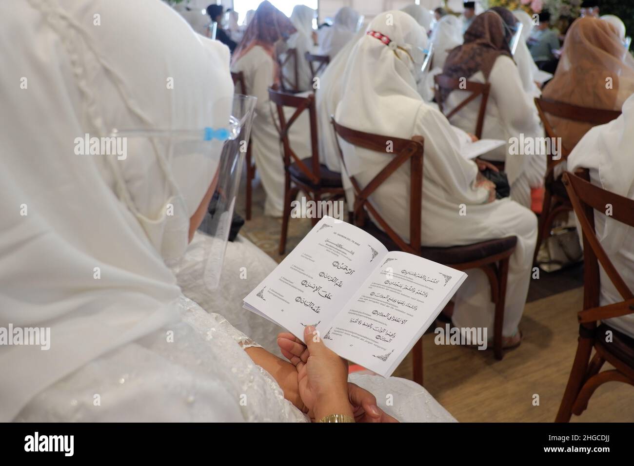Jakarta, Indonesien - Dezember 2020 : Eine Gruppe muslimischer Frauen trägt eine Gesichtsmaske und liest in einem Raum Gebetsbücher Stockfoto