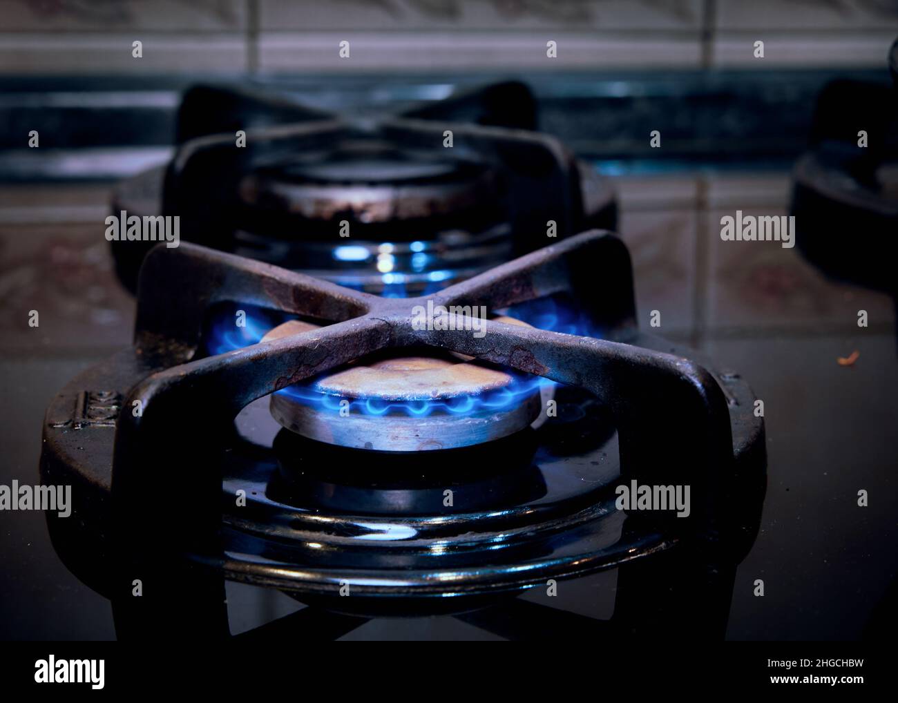 Die Flamme eines brennenden Gasbrenners auf einem Küchenherd. Stockfoto