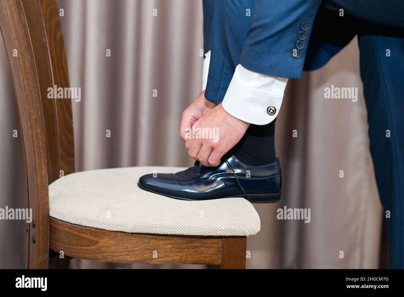 Ein junger Mann bindet die Schnürsenkel seiner Schuhe an - Detail, selektiver Fokus Stockfoto