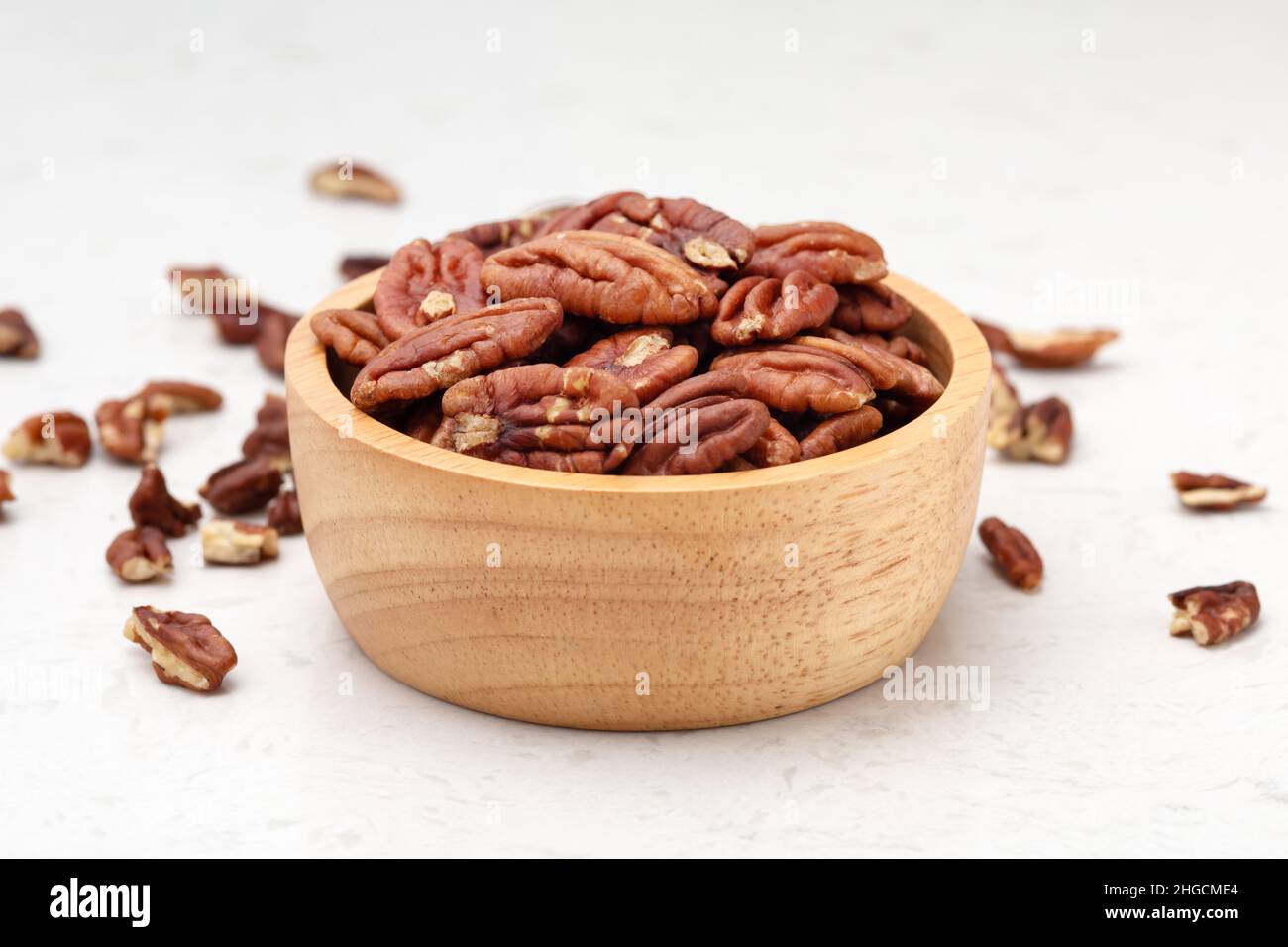 Pekannüsse in Holzschale auf Marmortisch Hintergrund Stockfoto