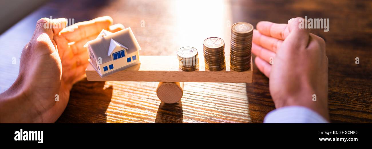 Immobilien-Haus Geld Gleichgewicht Im Maßstab Stockfoto