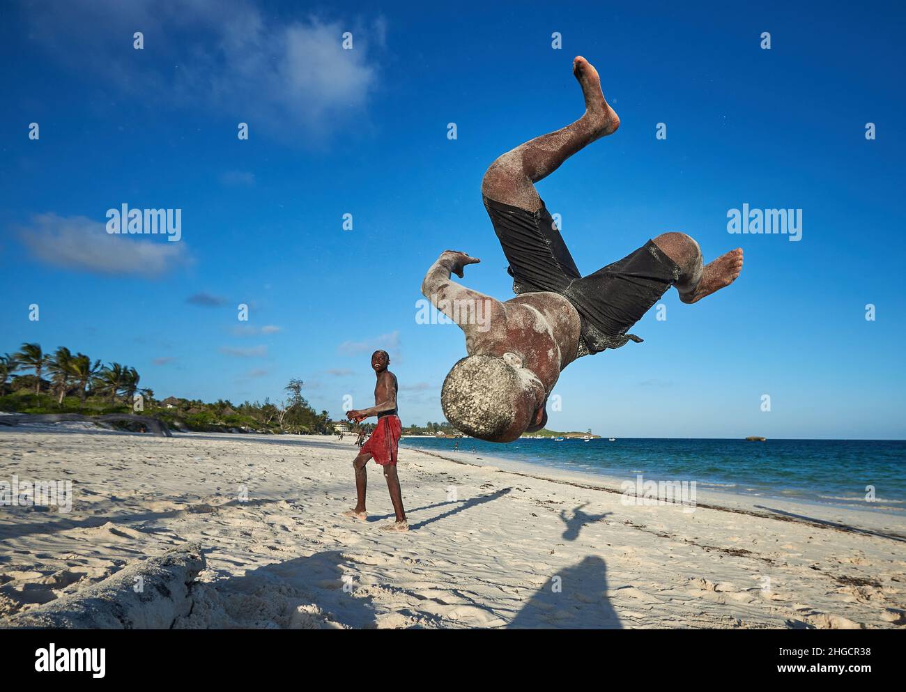 Junge, der Action-akrobatische Sprung eines afrikanischen jungen Mannes ausführt Luftdrehung eines Mannes am Strand in Watamu, Kenia, Afrika Junge männliche Jumping Stockfoto