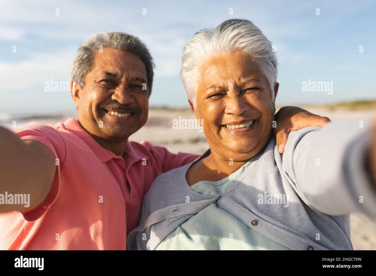Porträt eines lächelnden, multirassischen Seniorenpaares, das sich in den Ruhestand verabschiedet, während er am Strand Selfie gemacht hat Stockfoto