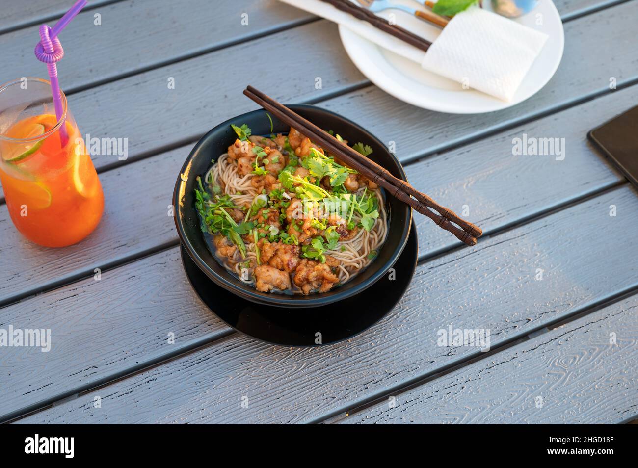 Asiatische Suppennudeln mit Huhn und Gemüse auf einem Tisch serviert. Chinesisches Restaurant Essen mit Kopieplatz Stockfoto