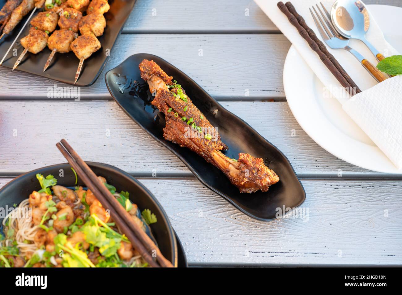 Chinesischer Lammgrill, der auf einem Teller in einem Restaurant mit Blick von oben serviert wird. Asiatisches Barbecue Street Food abstrakt, beliebter Nachtsnack Stockfoto