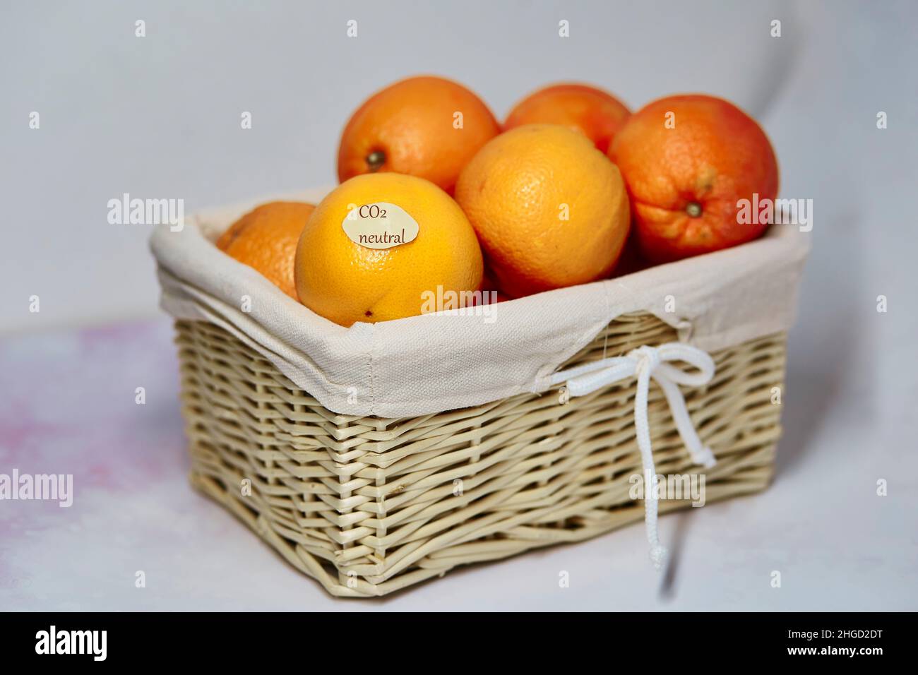 CO2 neutrales Etikett auf Orangen. CO2-Kennzeichnung. Netto kohlenstofffrei, emissionsfrei. Korbkorb mit klimaneutralem Produktetikett. Bio-Landwirtschaftsprodukte vom lokalen Markt Stockfoto