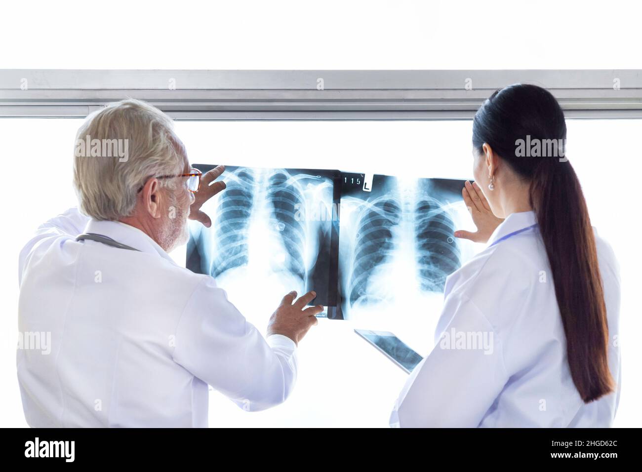 Ärzte des medizinischen Chirurgen schauen sich den Röntgenfilm an und besprechen die Behandlung vor der Operation im Krankenhaus. Stockfoto