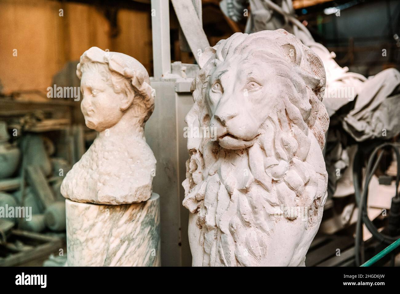 Handgemeißelte Statue eines Löwen in einer Marmorwerkstatt in Italien, die in einem Bergbau- und Produktionskonzept aus weißem Stein gemeißelt wurde Stockfoto