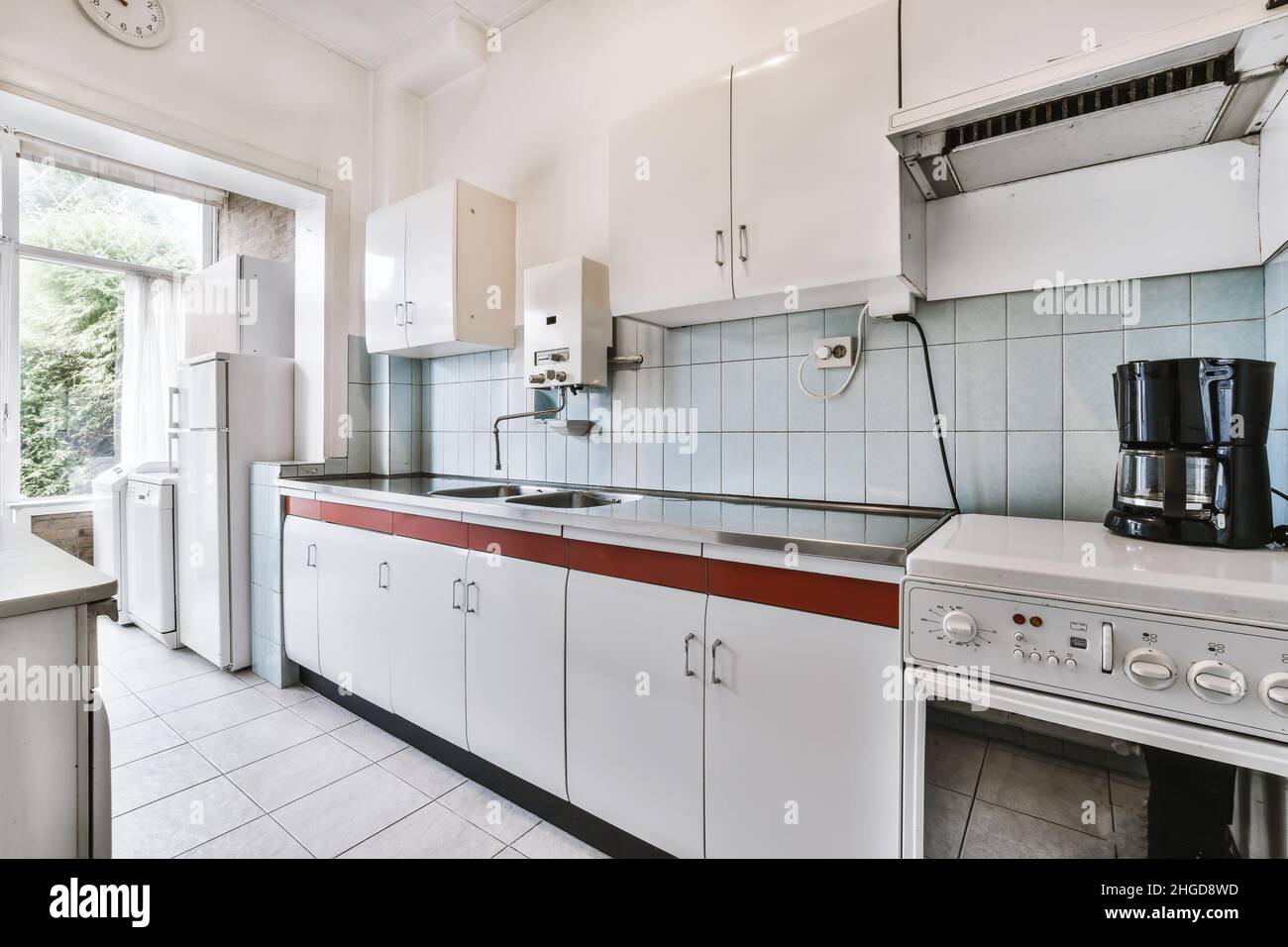 Tolle Küche mit Fliesenboden und weißem Küchenset Stockfoto