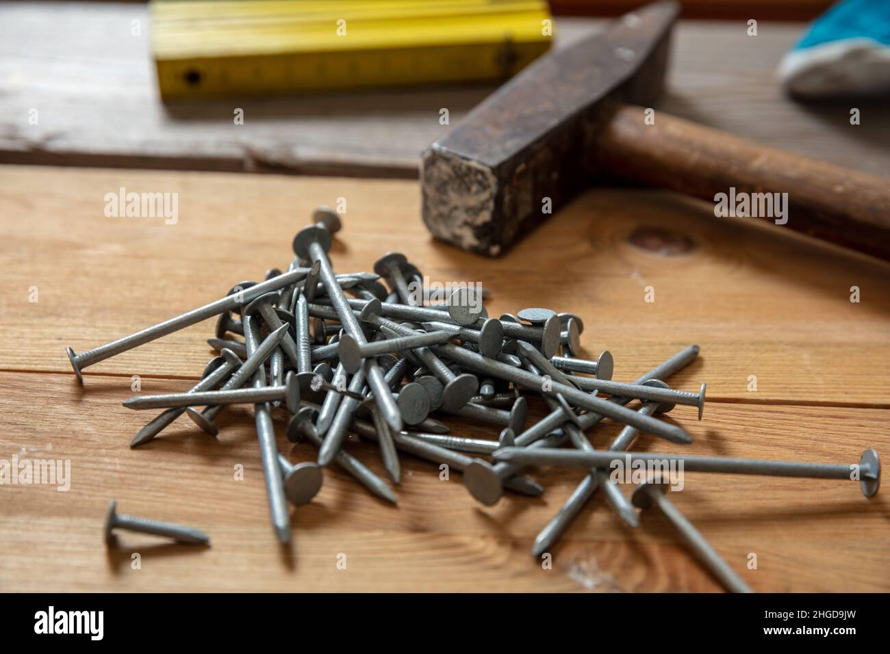 Hammer und Nagel stapeln auf Holz. Tischler Arbeitstisch, Nahaufnahme, Tischlerwerkstatt Stockfoto