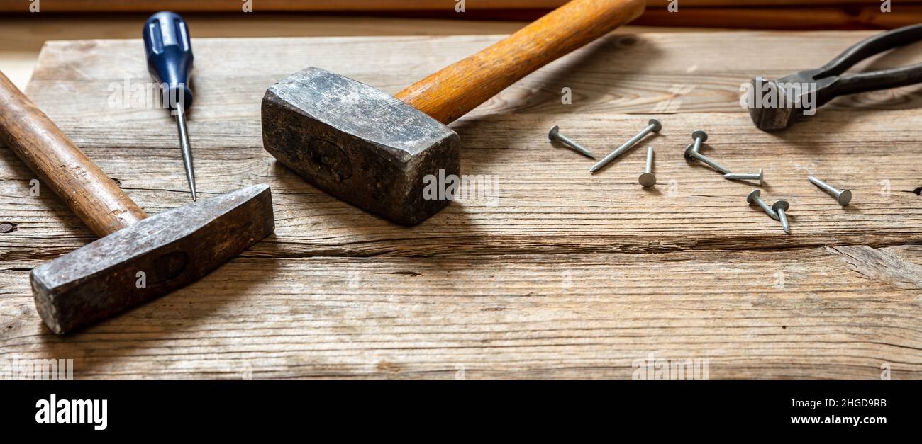Handwerkzeuge alt verwendet, Hammer, Vorschlaghammer Zangen und Nagel auf Holz, Tischler Arbeitstisch, Nahaufnahme Stockfoto