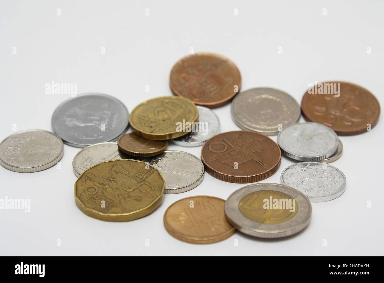 Münzen verschiedener Länder. Eine Streuung von Münzen auf weißem Hintergrund. Geringe Schärfentiefe Stockfoto