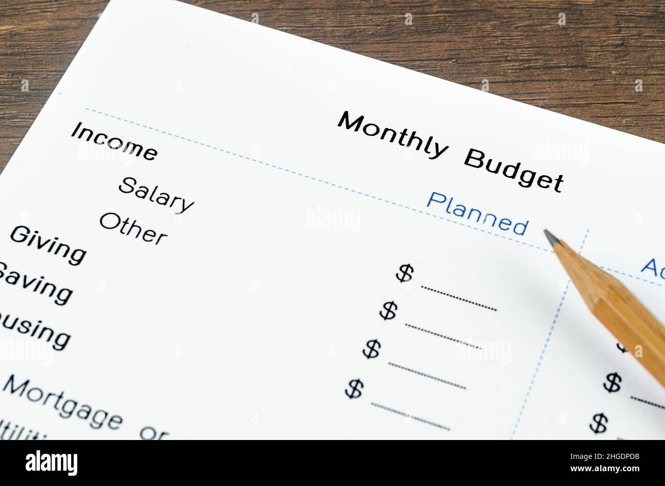 Ein Ausdruck aus einem monatlichen Budget für Ihren Text mit Bleistift auf Holzhintergrund. Stockfoto