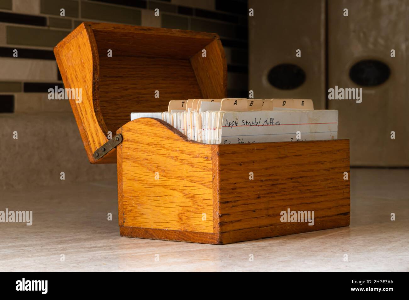 Holzrezept-Box auf der Küchentheke mit handgeschriebenen Rezepten Stockfoto