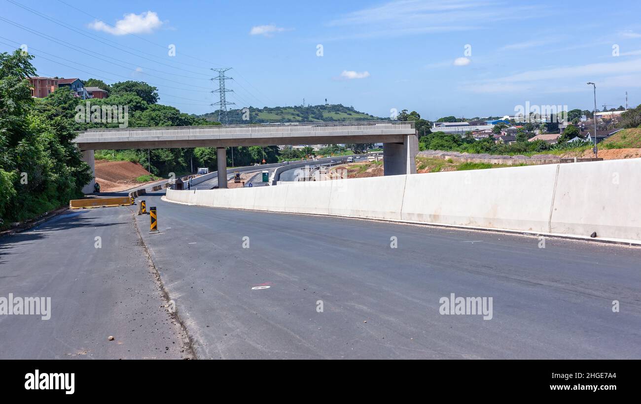 Bau einer Autobahn-Brücke mit Bushaltestelle und Poolstraßen an einem sommerblauen Tag. Stockfoto