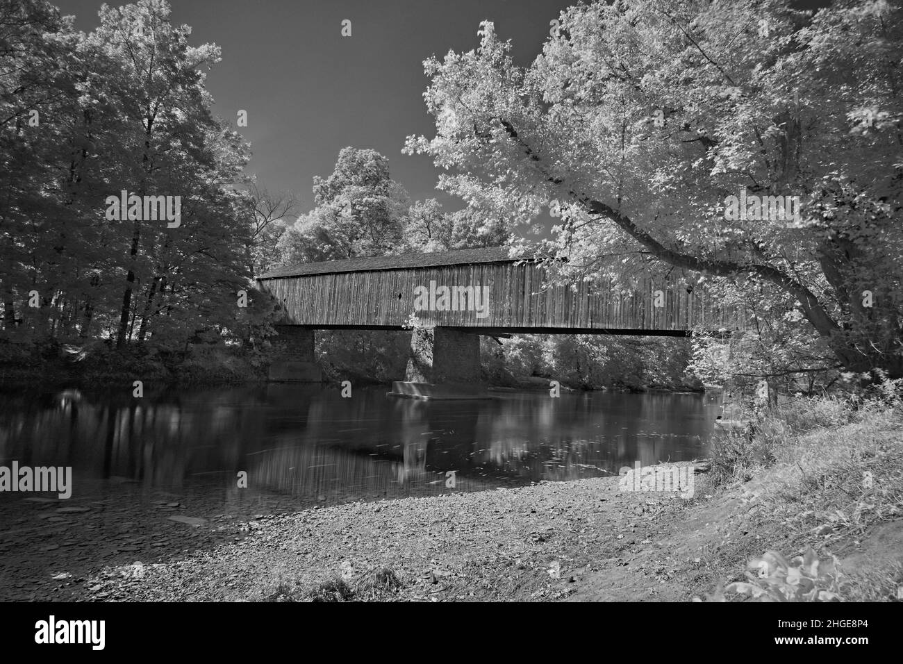 Schofield Ford bedeckte die Brücke im Tyler State Park in Bucks County, Pennsylvania, in gruseligen Schwarz-Weiß-Infrarotaufnahmen. Über Neshaminy Creek. Stockfoto
