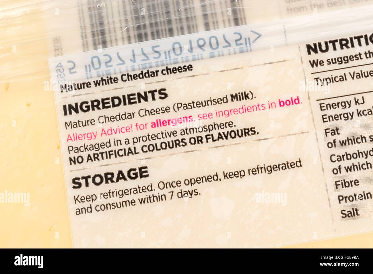 Nahaufnahme von ASDA-eigenen Cheddar-Käseetiketten mit Allergenwarnung in roter Schrift. Für Lebensmittelallergien und möglicherweise milchfreie Ernährung. Stockfoto