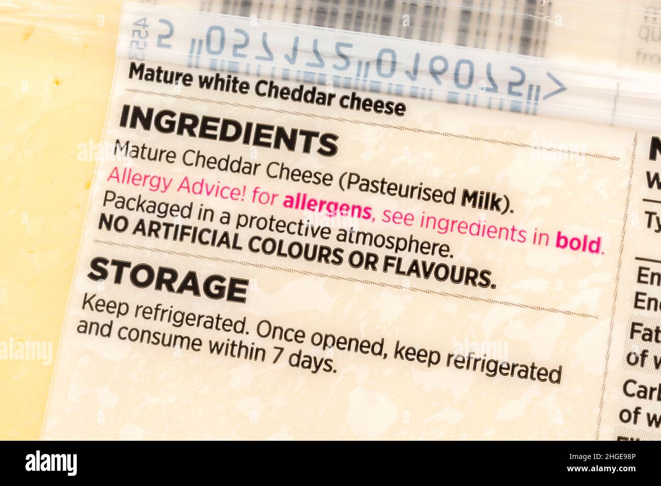 Nahaufnahme von ASDA-eigenen Cheddar-Käseetiketten mit Allergenwarnung in roter Schrift. Für Lebensmittelallergien und möglicherweise milchfreie Ernährung. Stockfoto