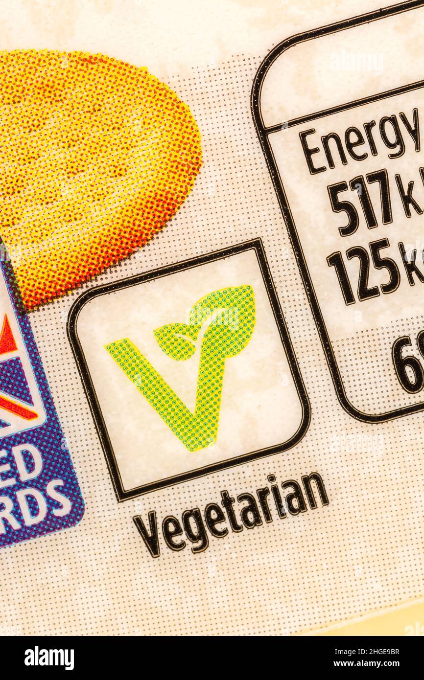 Makroaufnahme des grünen Vegetarian-Symbols auf ASDA-Plastikverpackung mit eigenem Etikett für reifen Cheddar-Käse. Konzentrieren Sie sich auf das „V“ und nicht auf das vegetarische Wort. Stockfoto