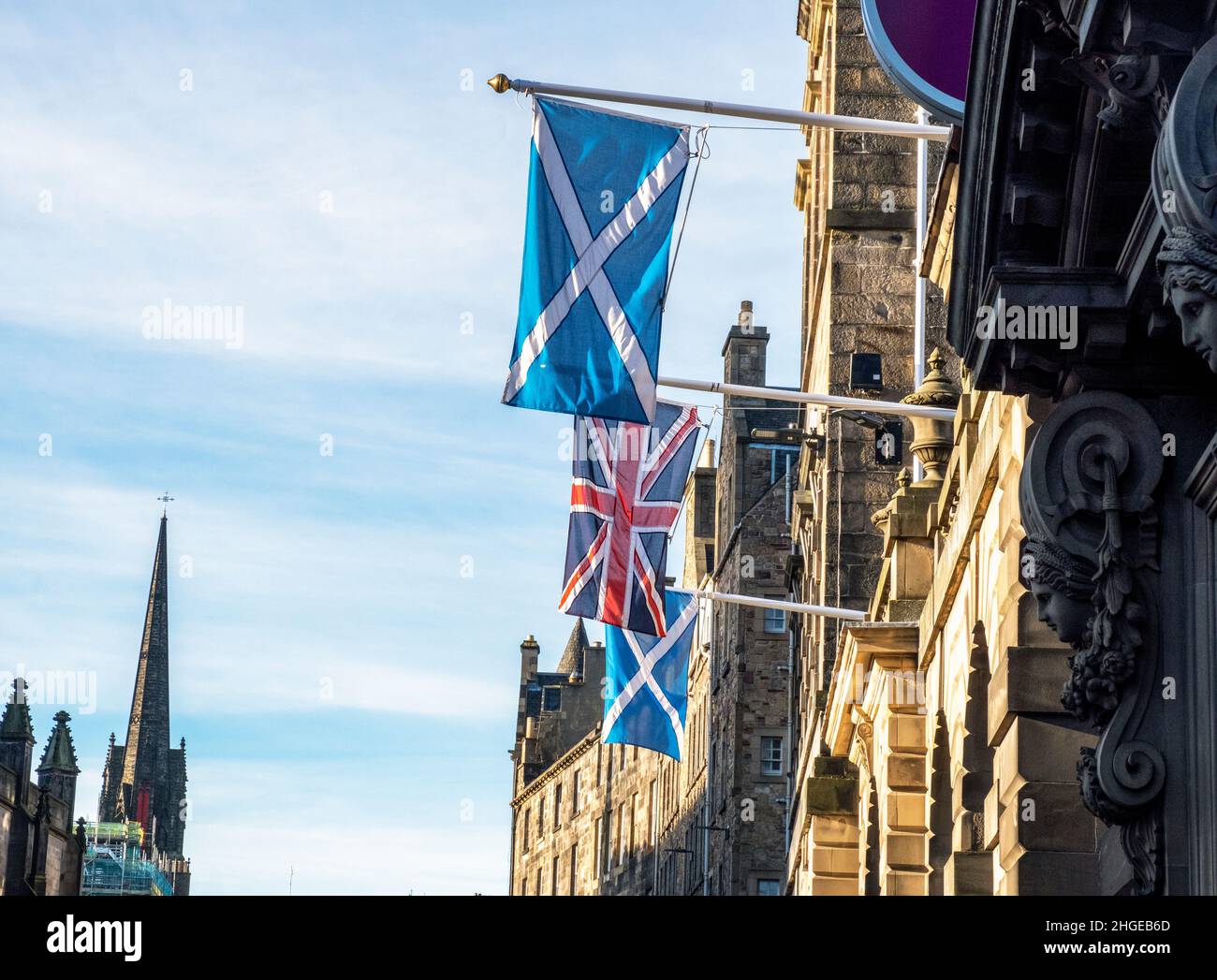 Die Flaggen Union Jack und Scottish Saltyre hängen vor den Edinburgh City Chambers auf der High Street in Edinburgh. Stockfoto
