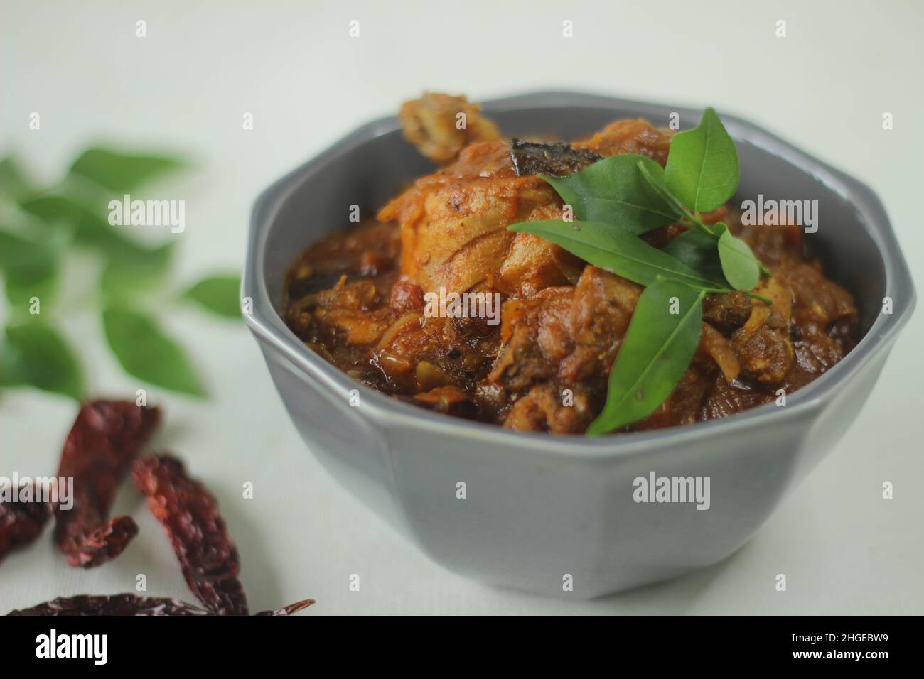 Chicken Soße. Halbtrockene Chicken Sovy im Kerala-Stil mit Zwiebeln, Tomaten und Gewürzen zubereitet. Aufgenommen auf weißem Hintergrund Stockfoto