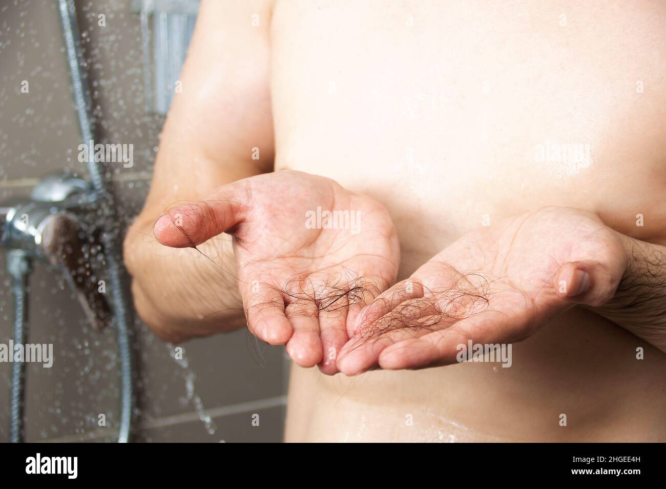 Nahaufnahme einer Hand, deren Haare in die Dusche fallen Stockfoto