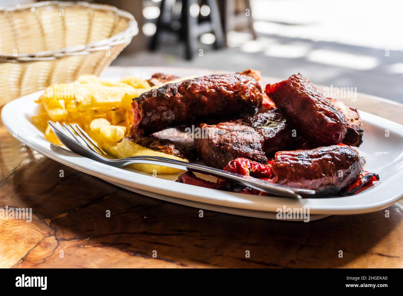 Auf Gran Canaria, Spanien, werden Wurst-, Kalb- und Schweinefleisch gegrillt und mit pommes frites serviert Stockfoto