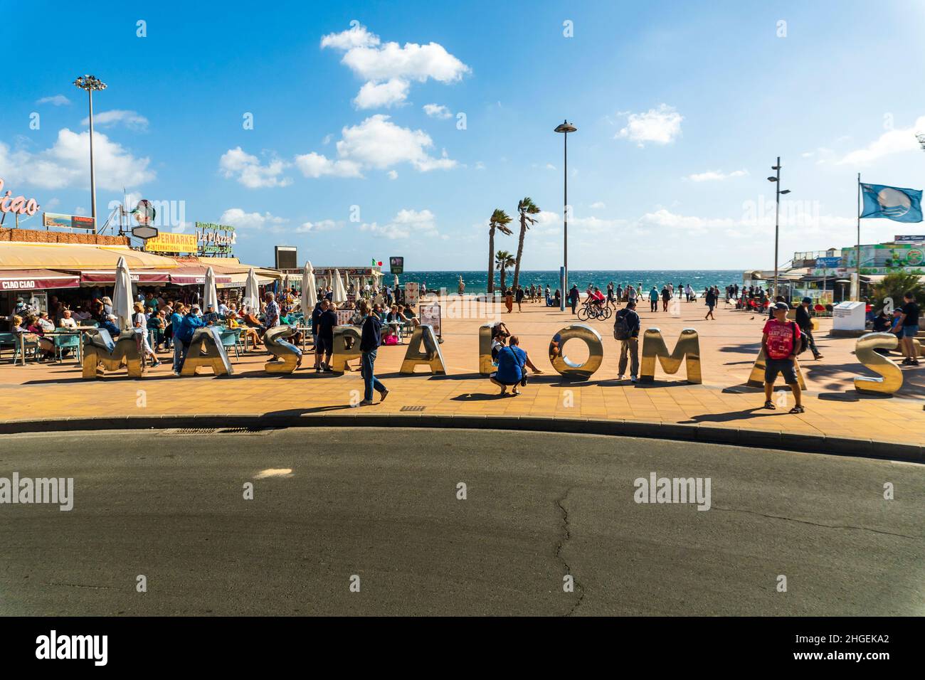 Maspalomas, Spanien - 5. Dezember 2021: Viele Touristen am Schild Maspalomas an der Küste von Playa del Ingles auf Gran Canaria. Stockfoto