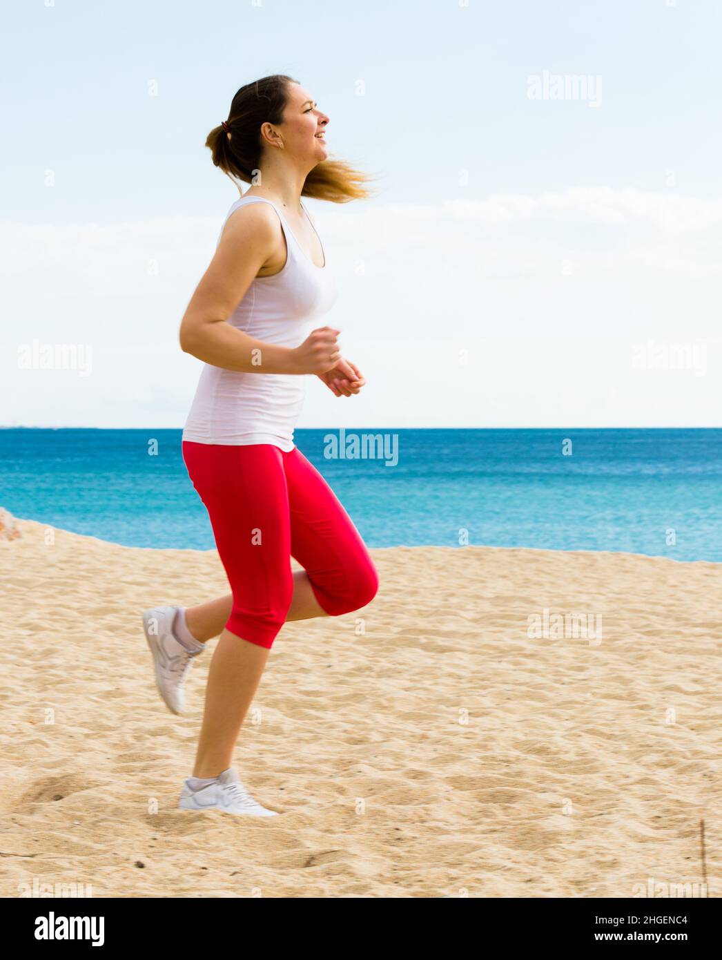 Frau laufen am Strand Stockfoto