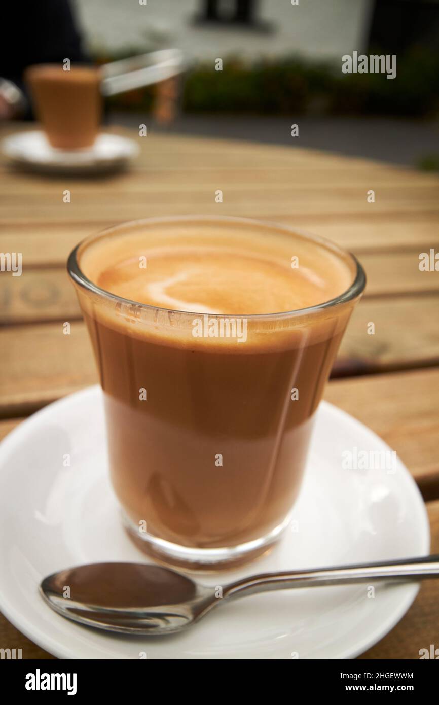 Zwei flache weiße Kaffees auf einem Kaffeetisch im Freien, hawkshead Lake District, cumbria, england, großbritannien Stockfoto