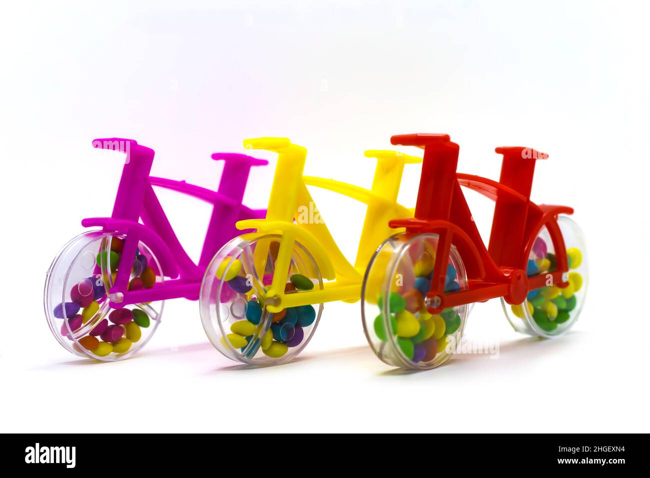 Plastikspielzeug Fahrrad mit Schokolade Nuss Süßigkeiten im Fahrradrad. Stockfoto
