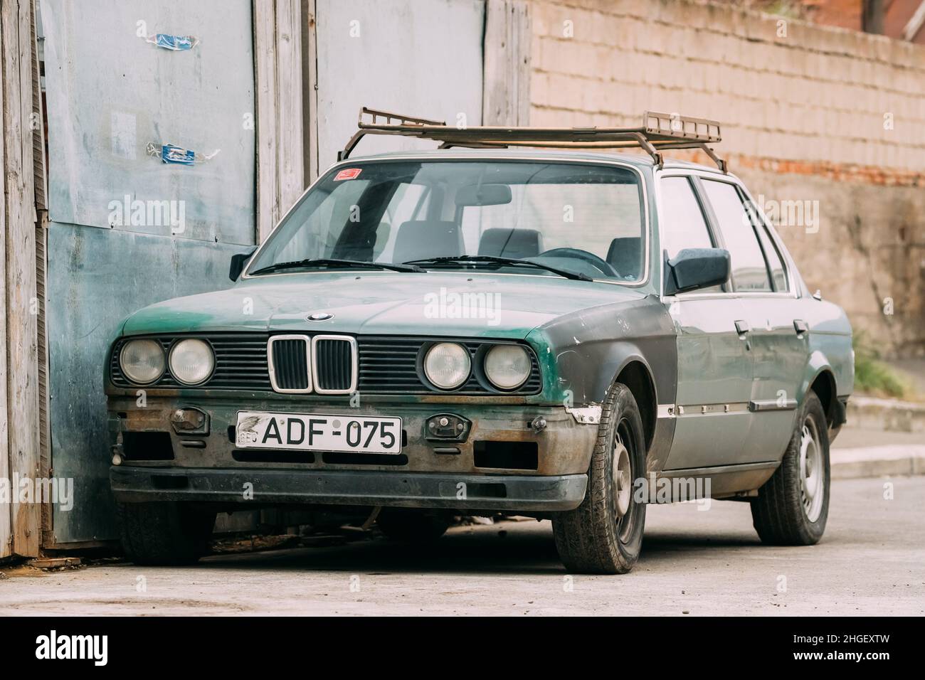 Alte rostige Limousine BMW 3 Series (E30) Parkplatz auf der Straße. Der BMW E30 ist ein Einstiegsmodell, das von BMW von 1982 bis 1994 produziert wurde. Stockfoto