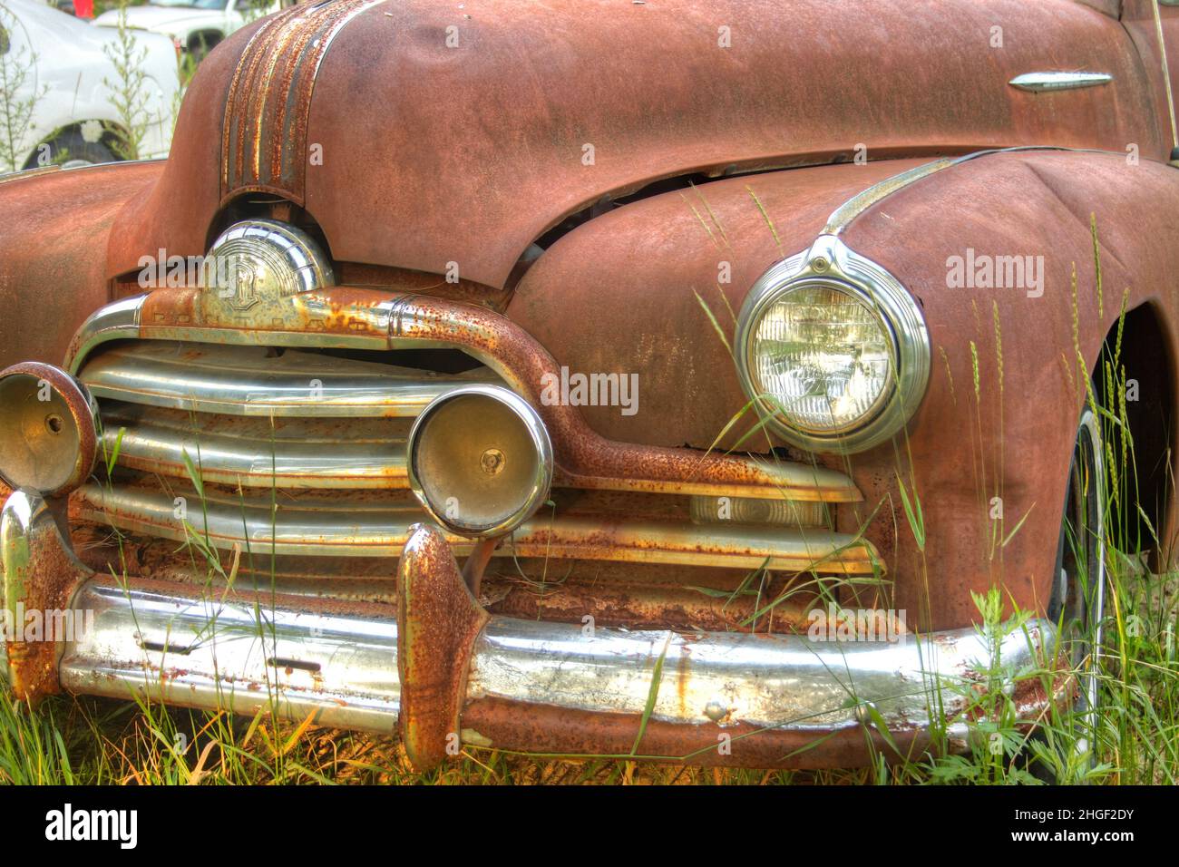 Vorderteil eines verlassenen rostigen alten Autos auf einem Feld Stockfoto