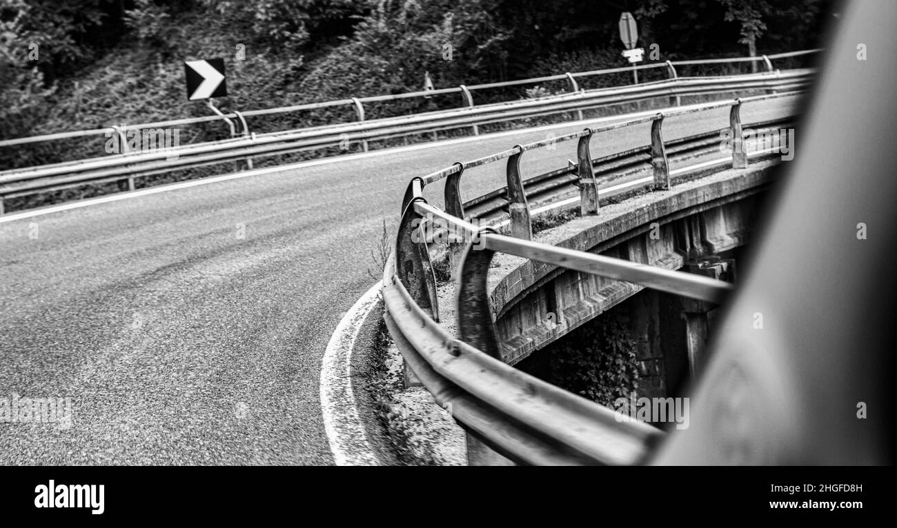 Eine enge, kurvenreiche Straße, die aus einem Auto genommen wurde. Stockfoto