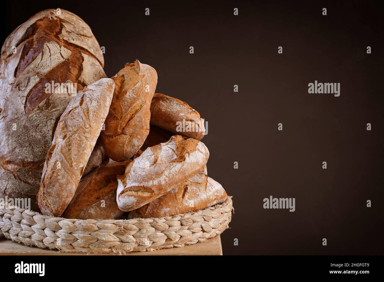 Korb mit handgefertigten Broten mit Platz für Kopien auf brauner Tafel Stockfoto