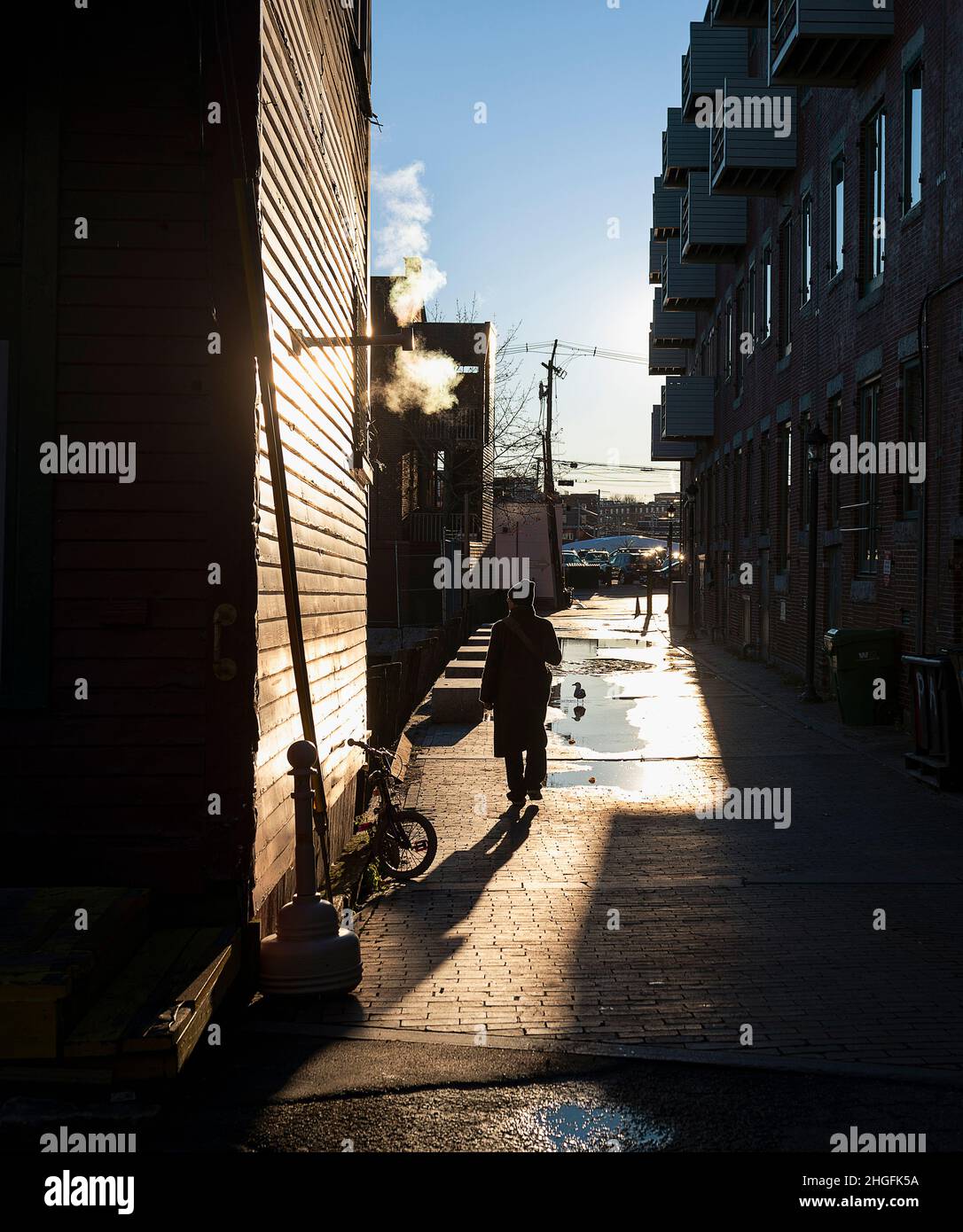 Eine Person in Silhouette, die durch den Old Port Bereich von Portland, Maine, spazierengeht. Stockfoto