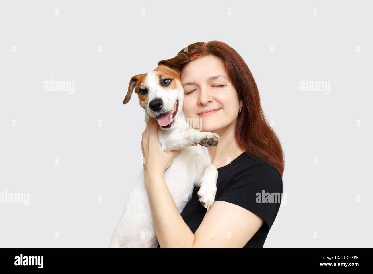 Brunette Mädchen umarmen und küssen ihren Hund Freund. Herzerwärmende Emotionen. Friends-Konzept. Stockfoto