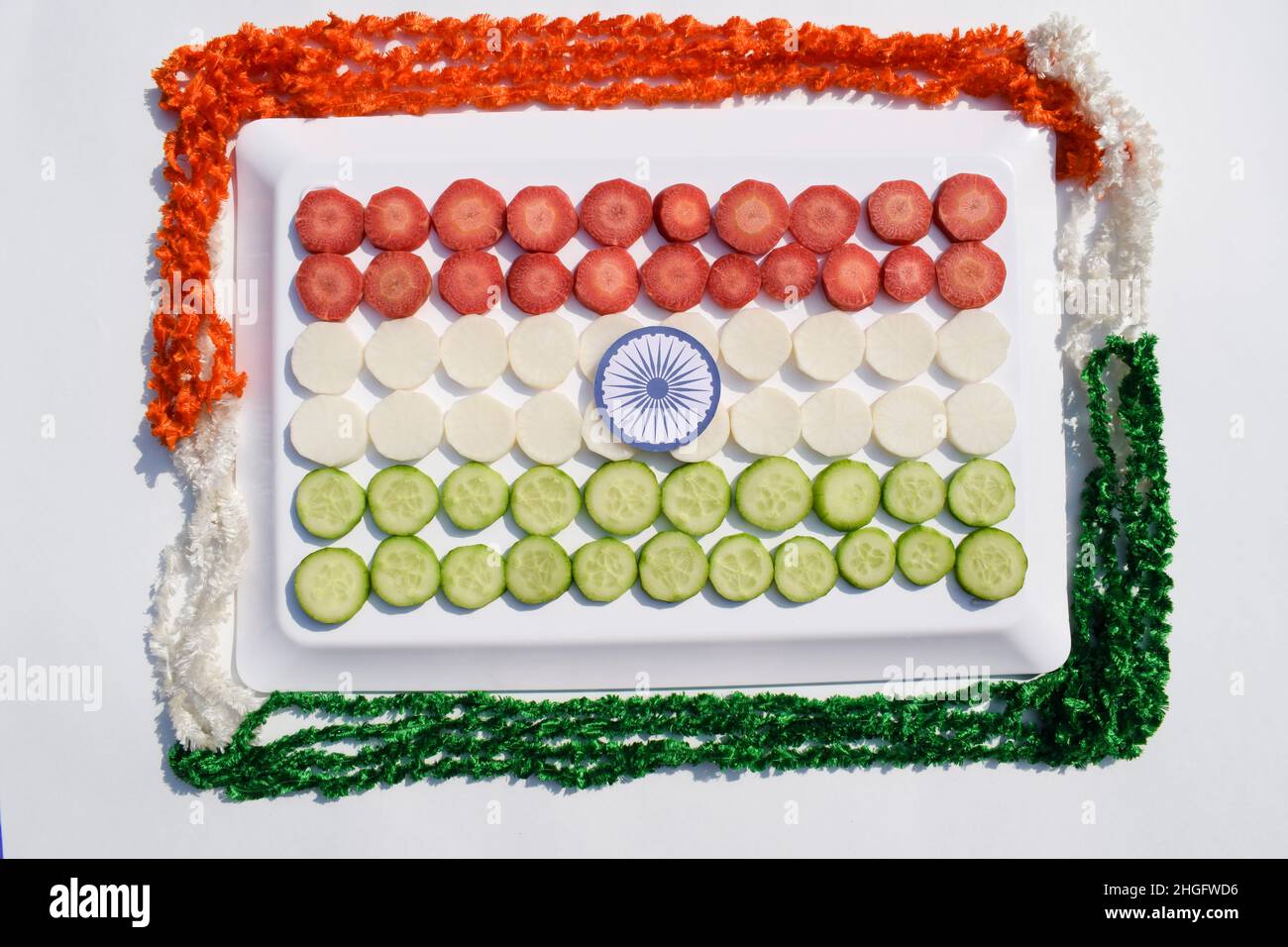 Republiktag von indien Lebensmittel tricolor Konzept. INDA-Flagge drei Farben dargestellt von Karotte, Rettich, Gurke in Scheiben geschnitten mit ashok Chakra mit Band Decorat Stockfoto