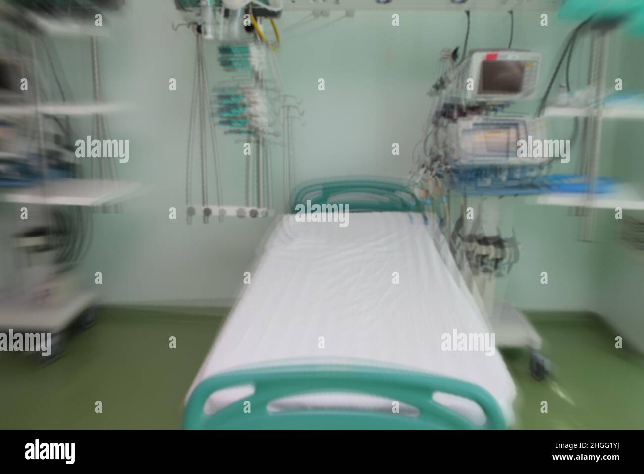 Verschwommenes Krankenhauszimmer mit leerem Bett, bereit für die Aufnahme des Patienten, unfokussierter Hintergrund. Stockfoto
