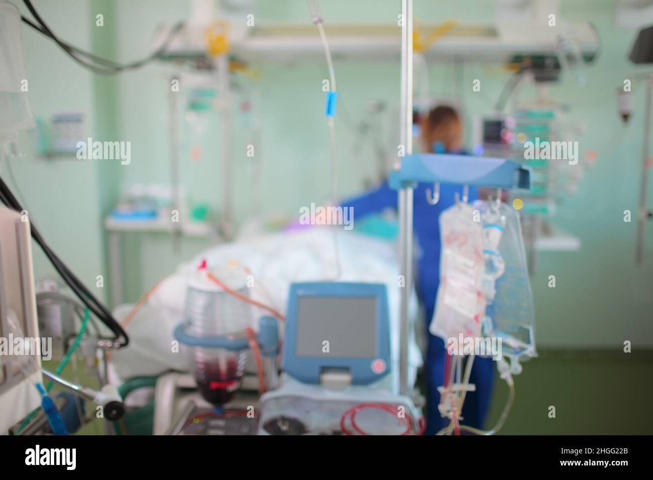 Krankenschwester, die ihre Arbeit mit einer kritischen Patientin auf der Intensivstation verrichtet, unfokussierter Hintergrund. Stockfoto