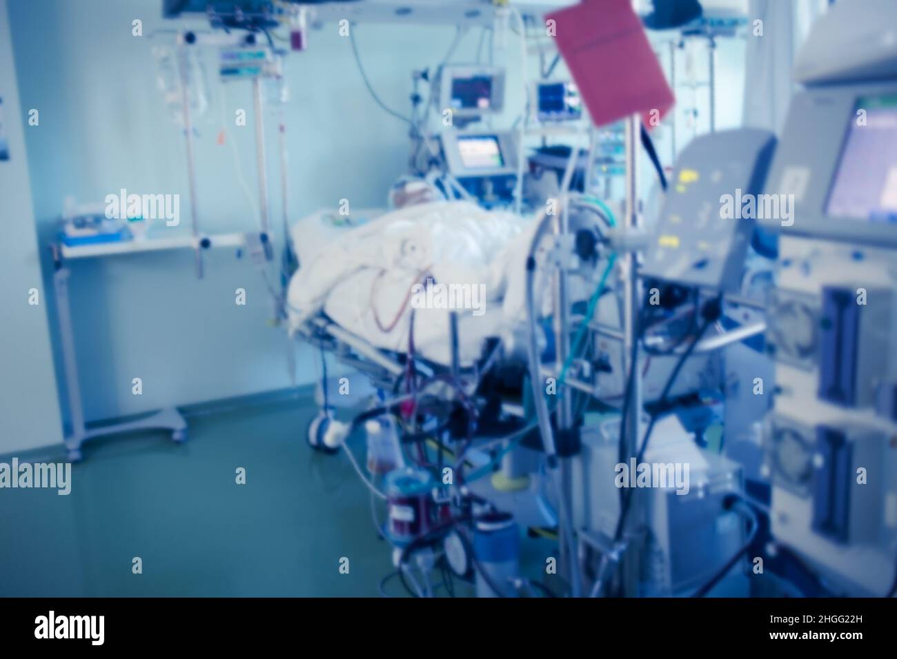 Hochentwickelte digitale Geräte, die auf der Intensivstation unter Überwachung der Uhr an den Patienten angeschlossen sind. Stockfoto