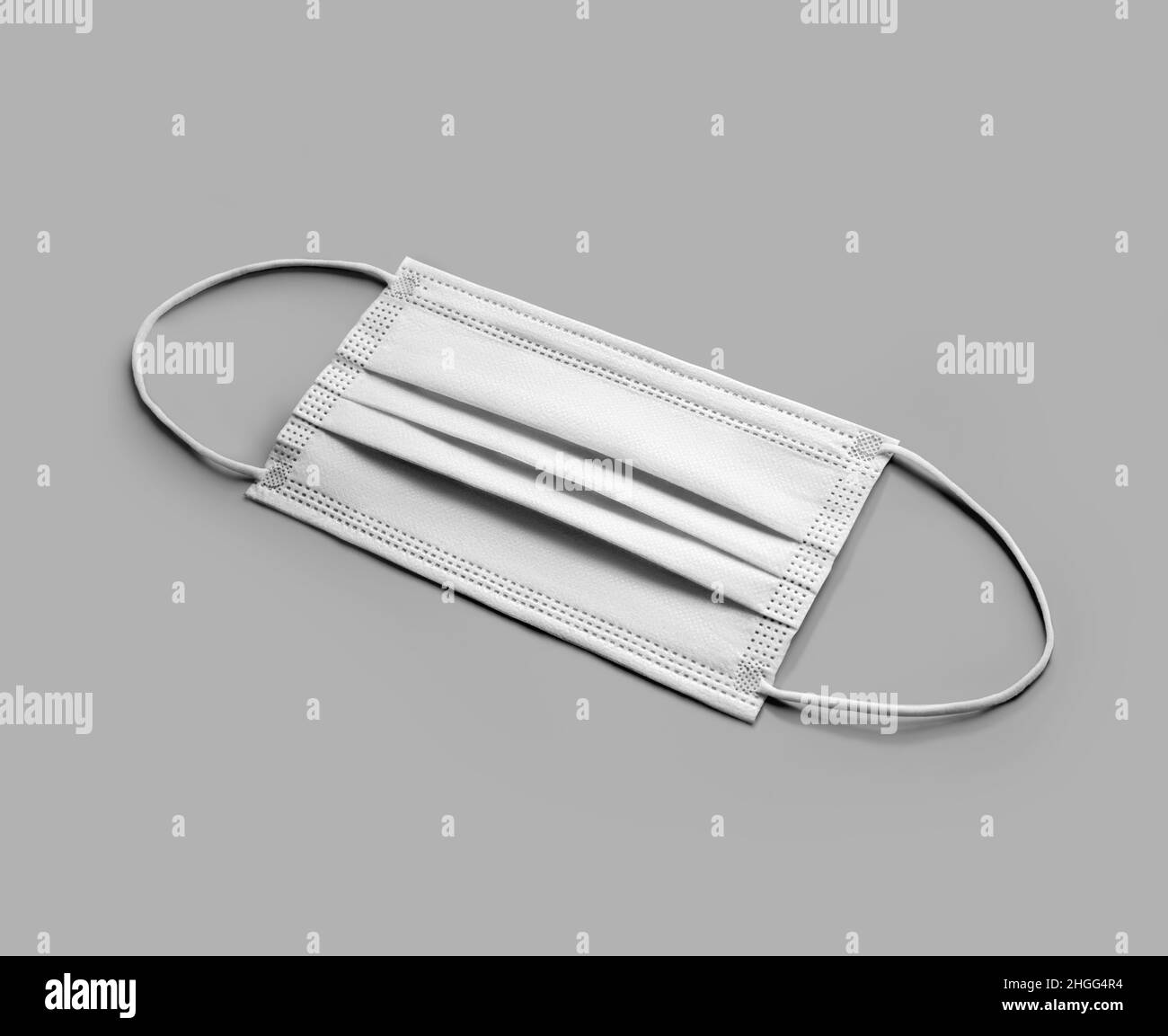 Nachbildung einer sauberen, gefalteten weißen OP-Maske mit isolierten Ohrschlaufen auf dem Hintergrund. Atemschutzmaske zum Schutz vor Epidemien, Influenza und Viren. B Stockfoto
