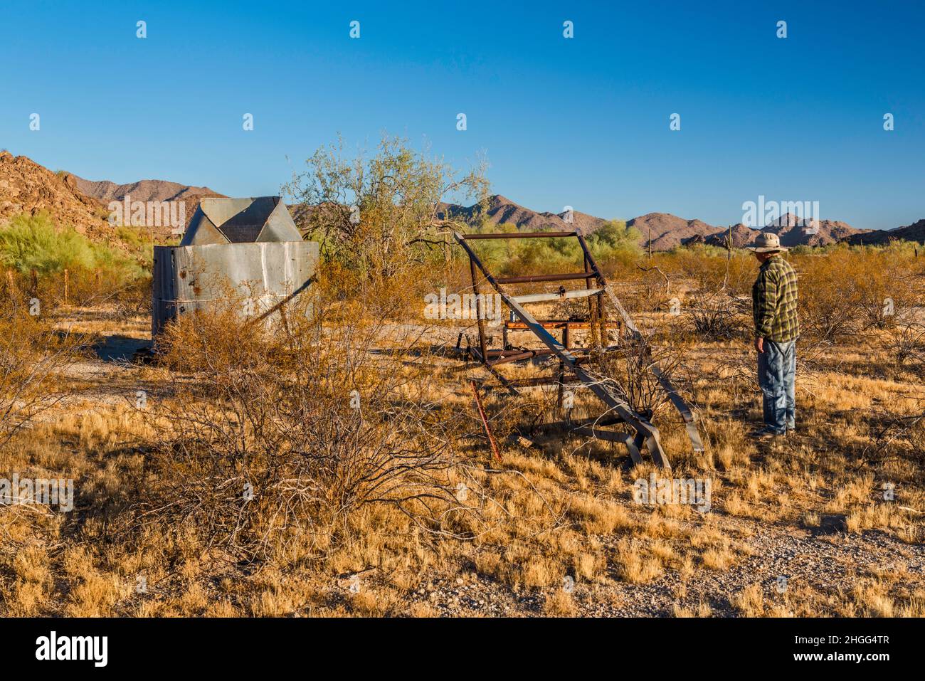 Wanderer am eingestürzten Windpumpenmast, Wasserbehälter am Hazen Well, ehemalige Ranch in Margies Cove, Maricopa Mtns, Sonoran Desert National Monument, USA Stockfoto