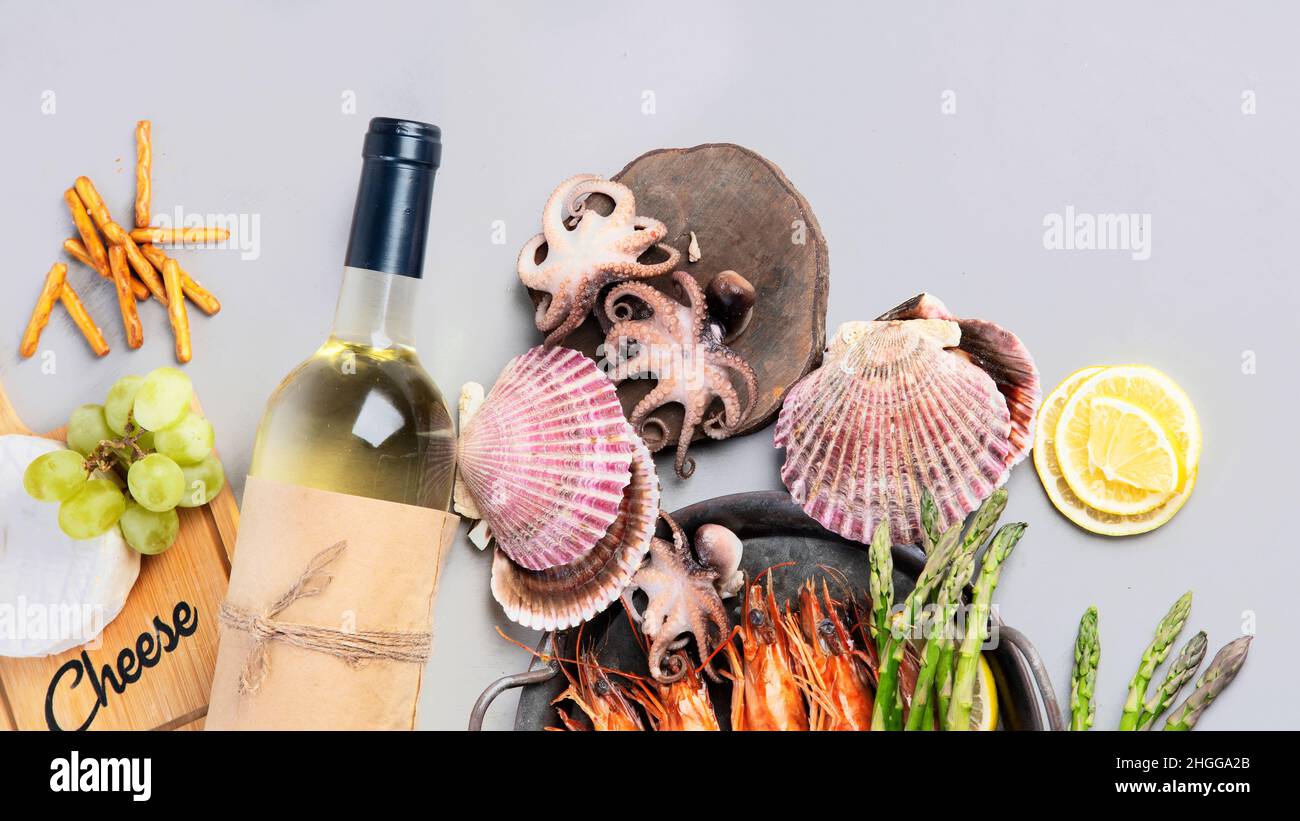 Weißweinflasche auf grauem Hintergrund. Meeresfrüchte und Vorspeisen. Draufsicht, flach liegend, Kopierbereich Stockfoto