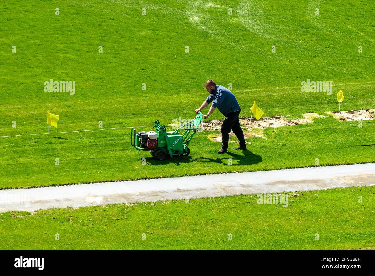 Kiew, Ukraine - 28. April 2021: Am Vorabend des Spiels mäht ein Mann im Fußballstadion den Rasen. Stockfoto
